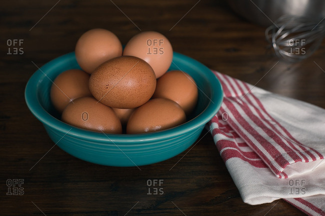 Bowl of fresh brown eggs on table
