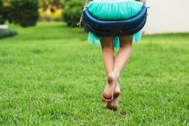 Girl with bare feet on swing