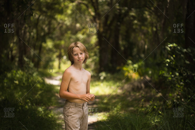 Boy standing on a forest path