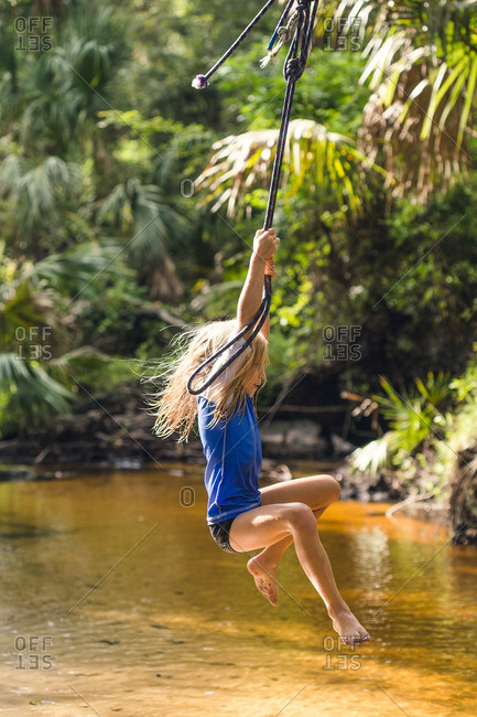 A girl on stream rope swing