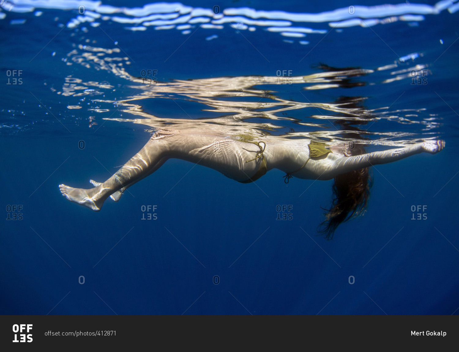 Underwater View Of Woman Floating At The Ocean S Surface Stock Photo