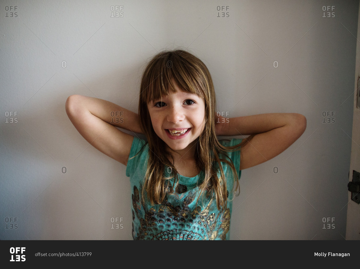 Little girl standing with her hands behind her head stock photo OFFSET