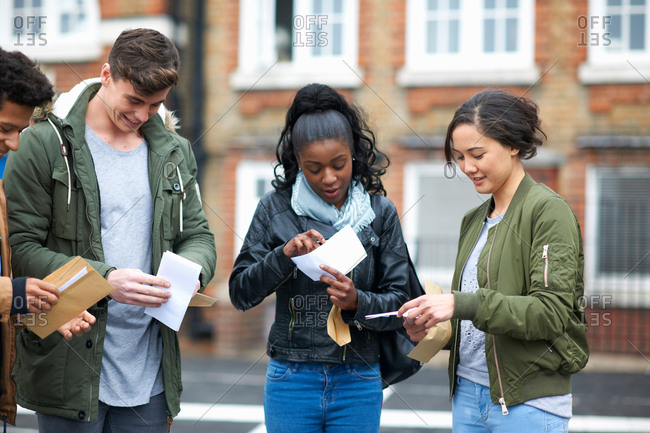 Young adult college students reading exam results on campus