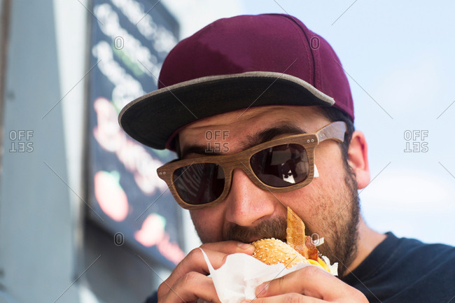 Male customer eating hamburger from fast food van