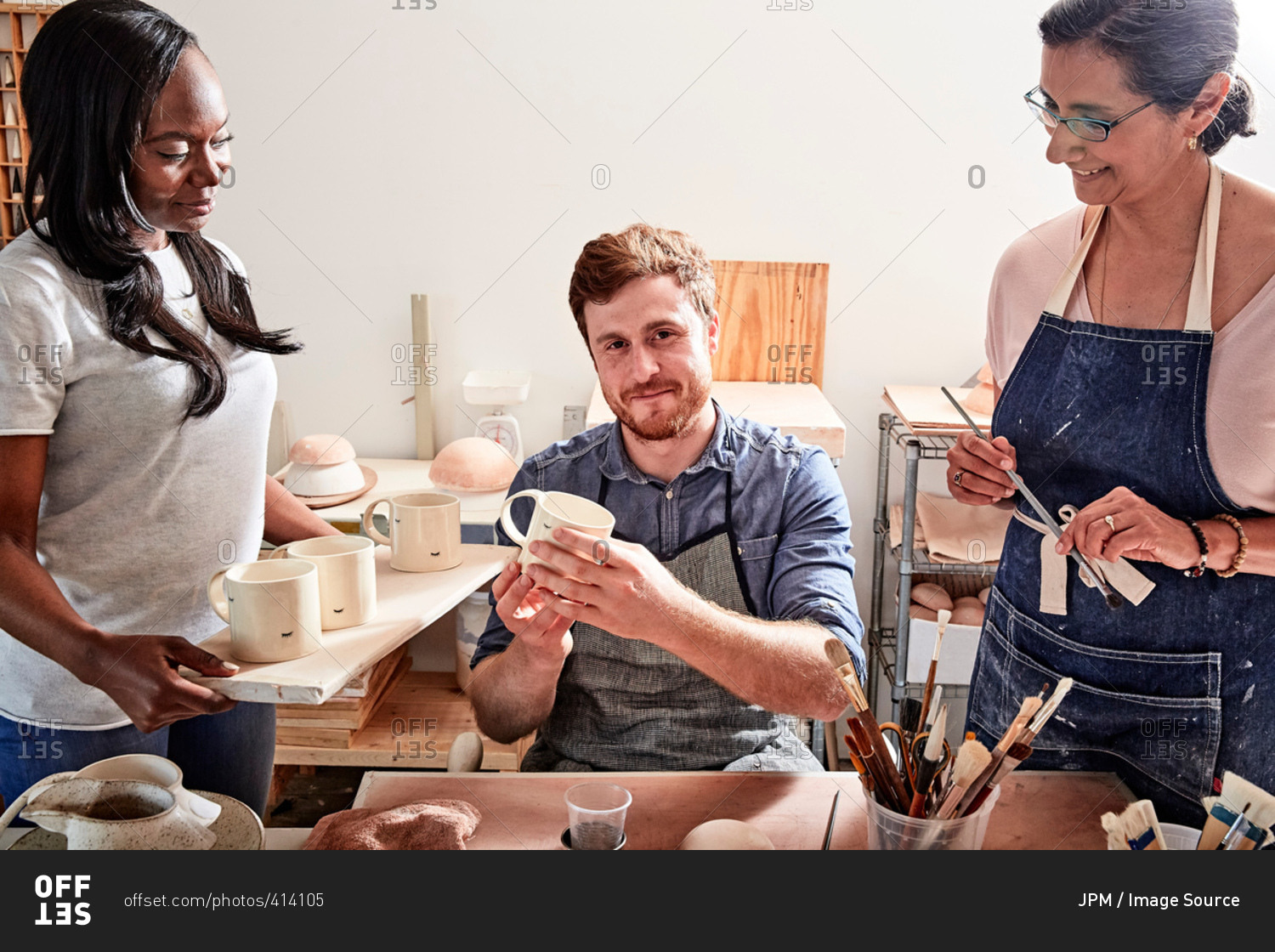 Group of people painting pottery in workshop