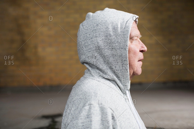 Side view of man wearing hooded top looking away