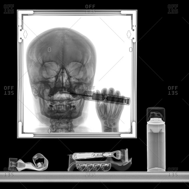 X-ray of a person brushing teeth in bathroom mirror