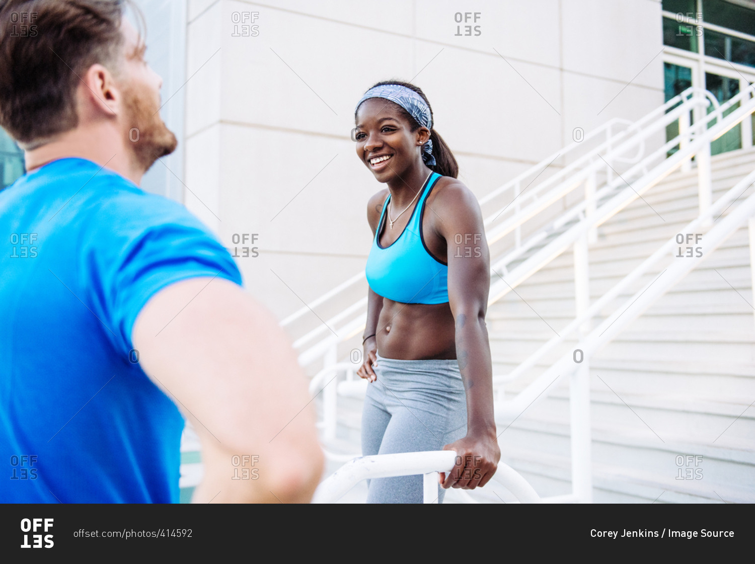 High angle view of man and woman training, taking a break on stairway at sport facility, downtown San Diego, California, USA