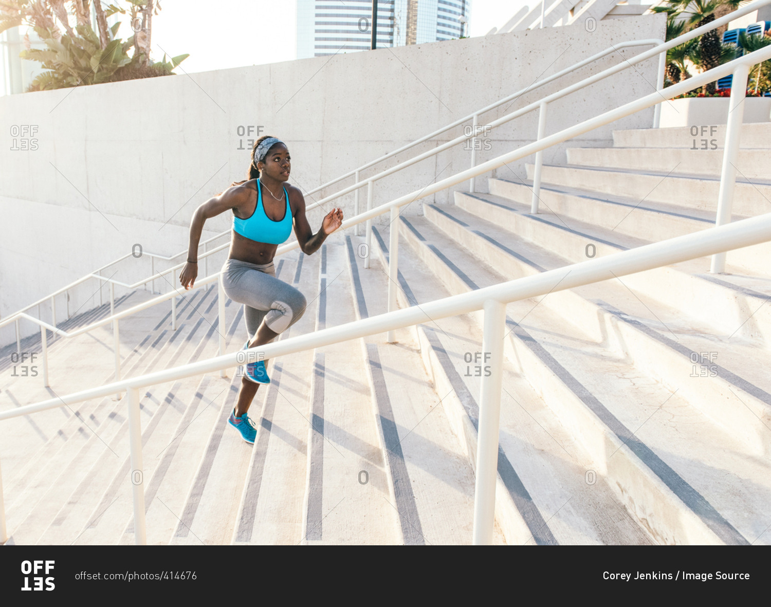 Young woman training, running up sport facility stairway, downtown San Diego, California, USA