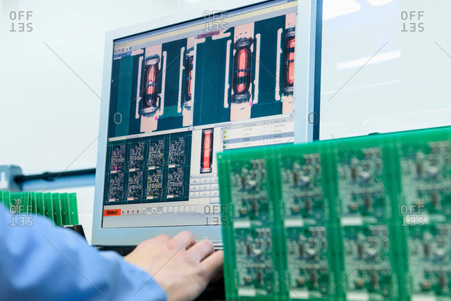 Worker testing circuit boards in circuit board assembly factory, close up