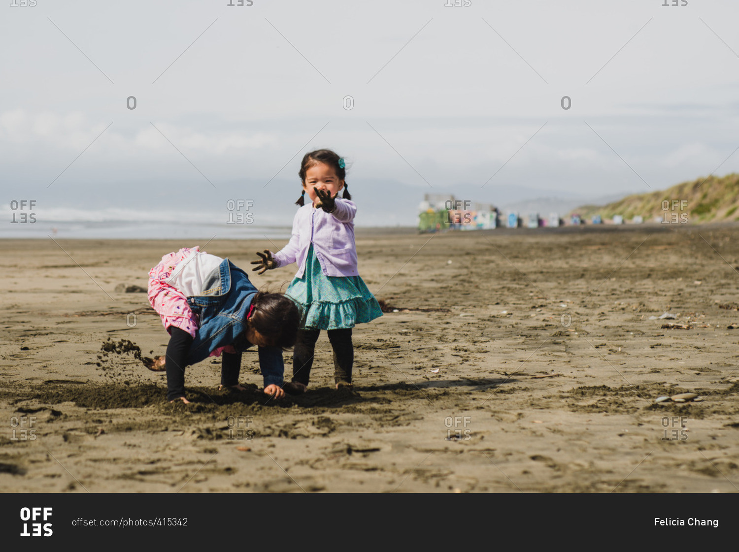 Little girl looking between her legs at the camera and smiling