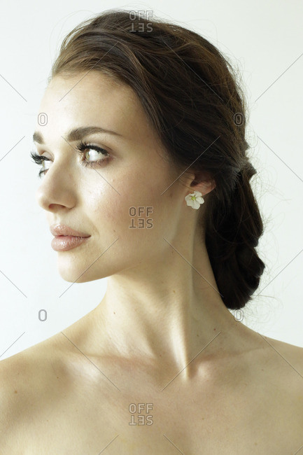 Portrait of a woman with brown hair tied in an elegant bun stock photo -  OFFSET