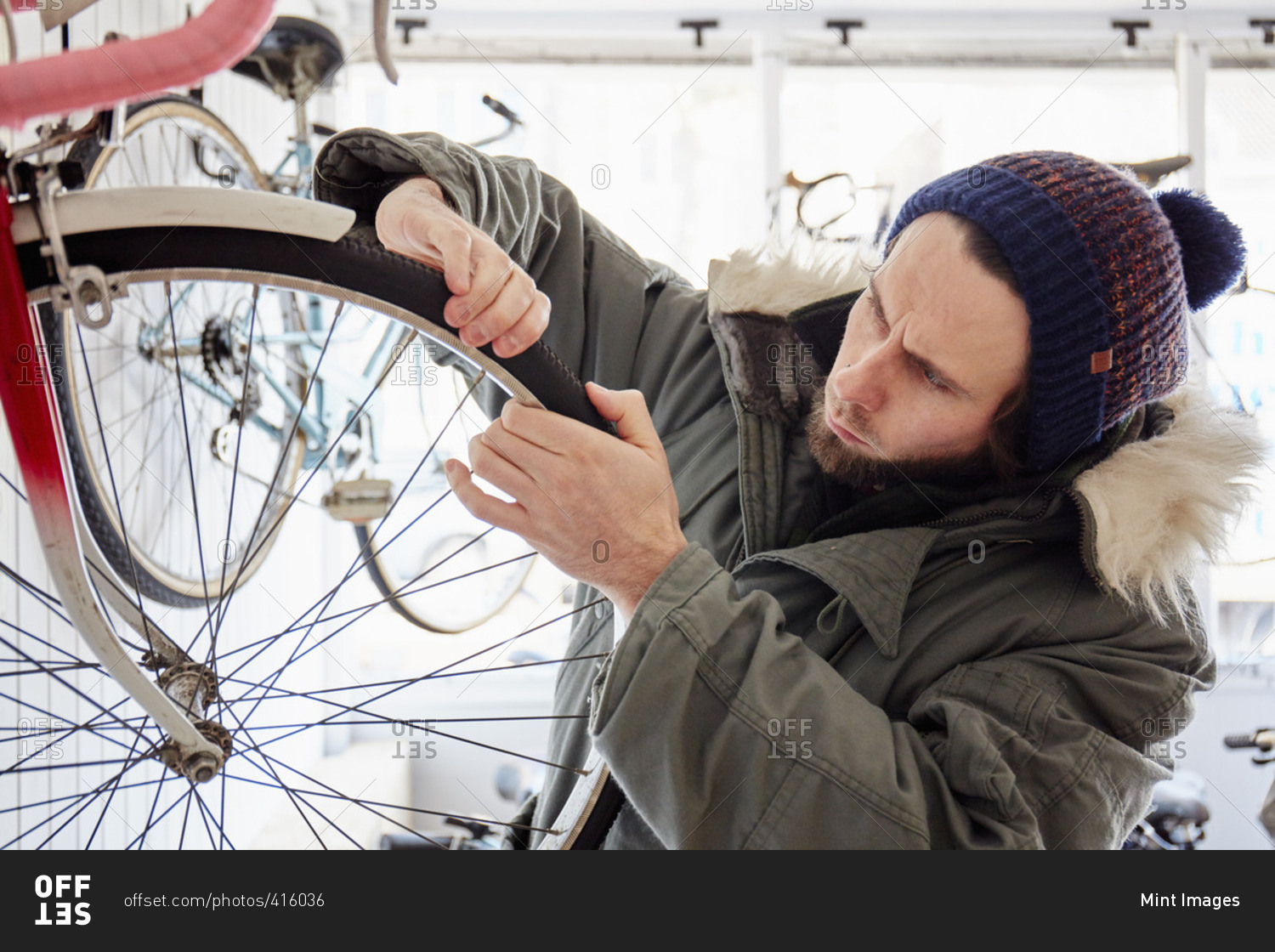 A young man working in a cycle shop, repairing a bicycle