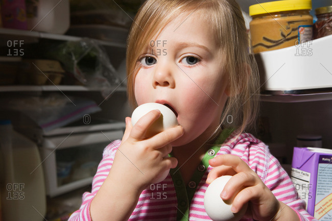Girl trying to eat egg