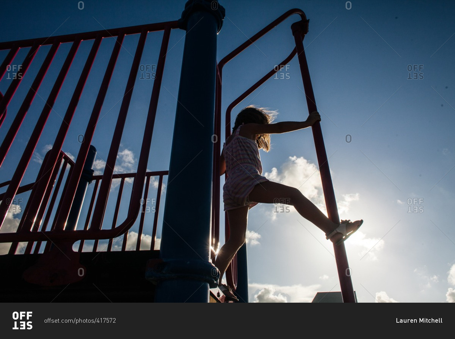Girl playing on a fireman\'s pole at a playground