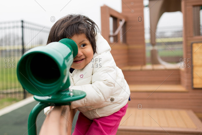 Toddler girl looking through telescope