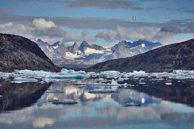 Reflections of ice and distant mountains in the Johan Petersen Fjord, Greenland
