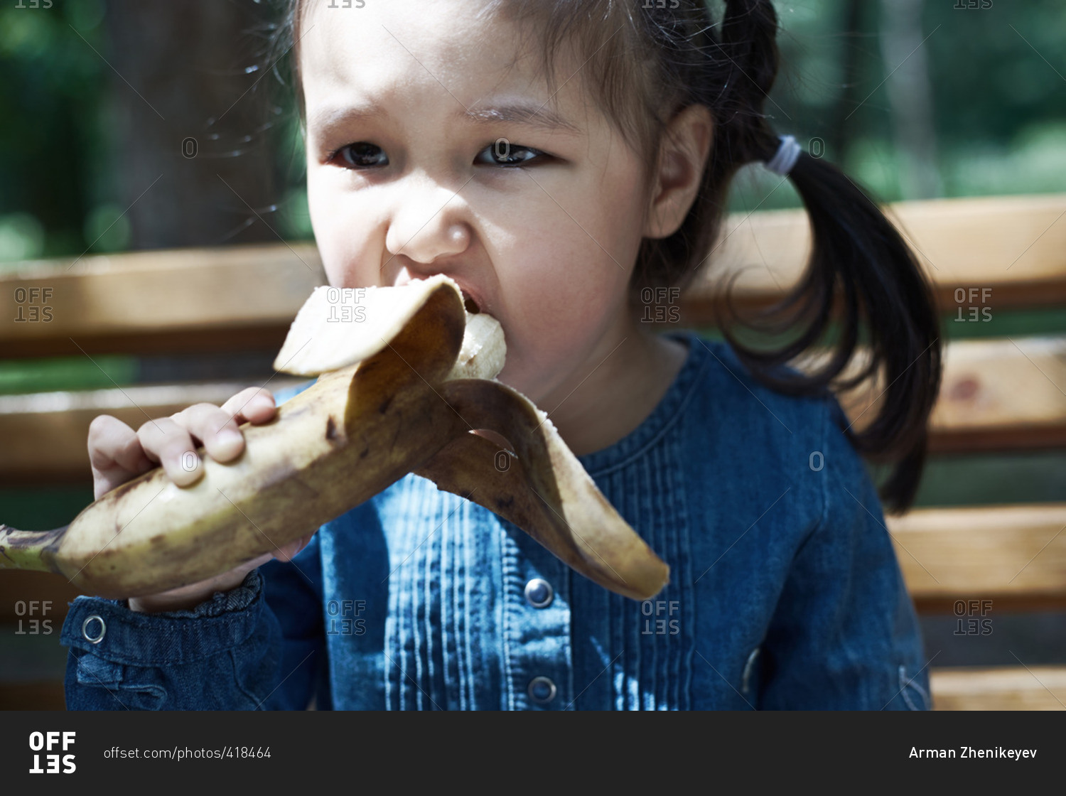 Girl eating a banana outdoors
