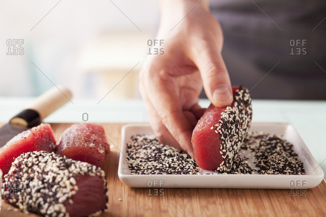 Tuna pieces being turned in black and white sesame seeds