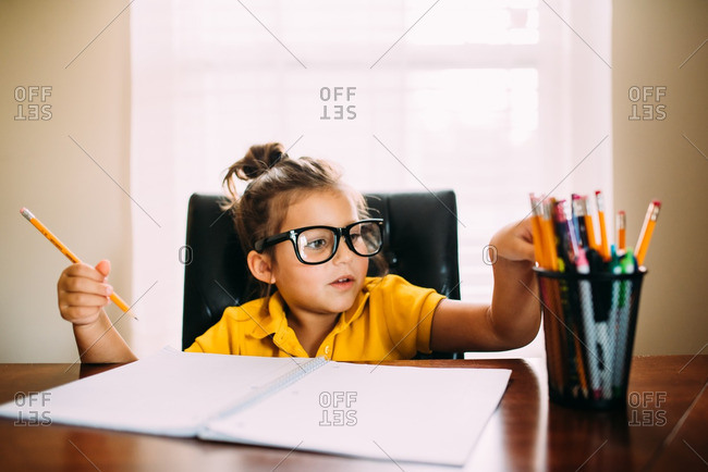 Studious Girl Picking A Pencil Stock Photo - Offset