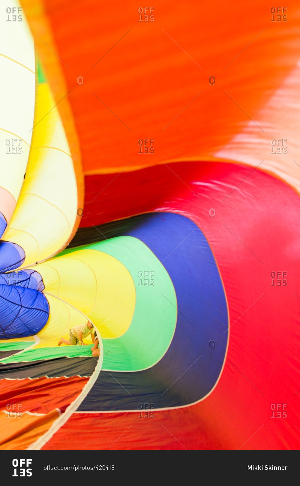 Children playing inside an inflatable rainbow parachute