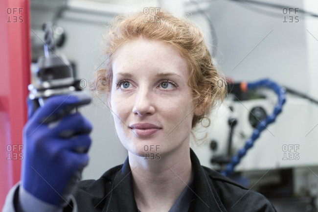 Young female engineer working with drill bit in an industrial plant, Freiburg im Breisgau, Baden-Wurttemberg, Germany