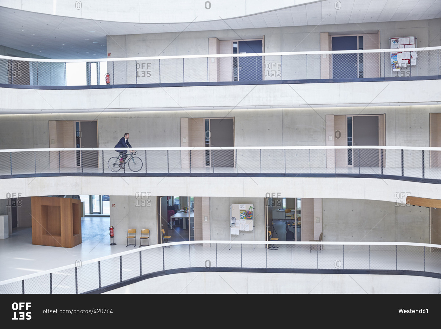 Businessman riding bicycle in modern office building