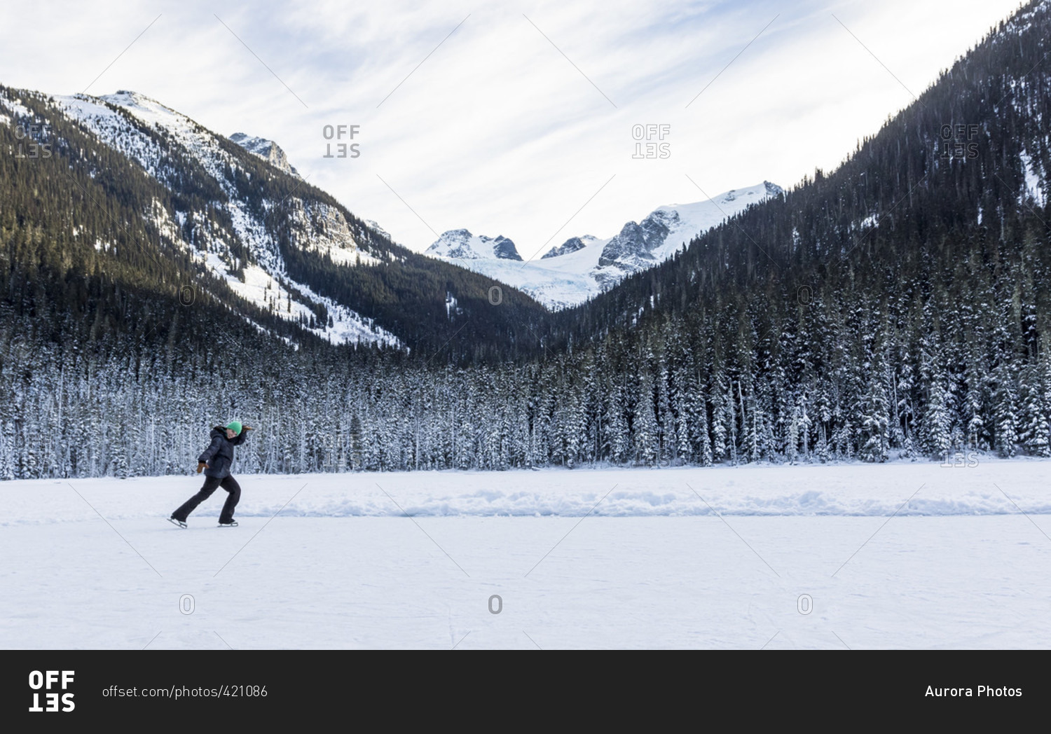 A Girl Ice Skates On A Cold Winter Day On Joffre Lake In British Columbia