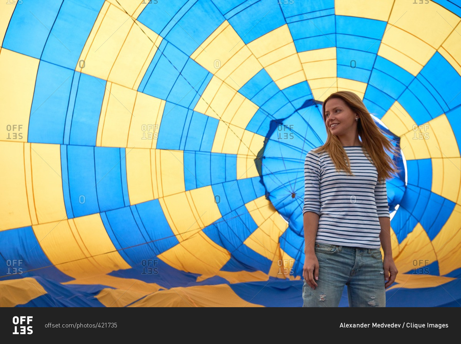 Young girl standing against inflating hot air balloon