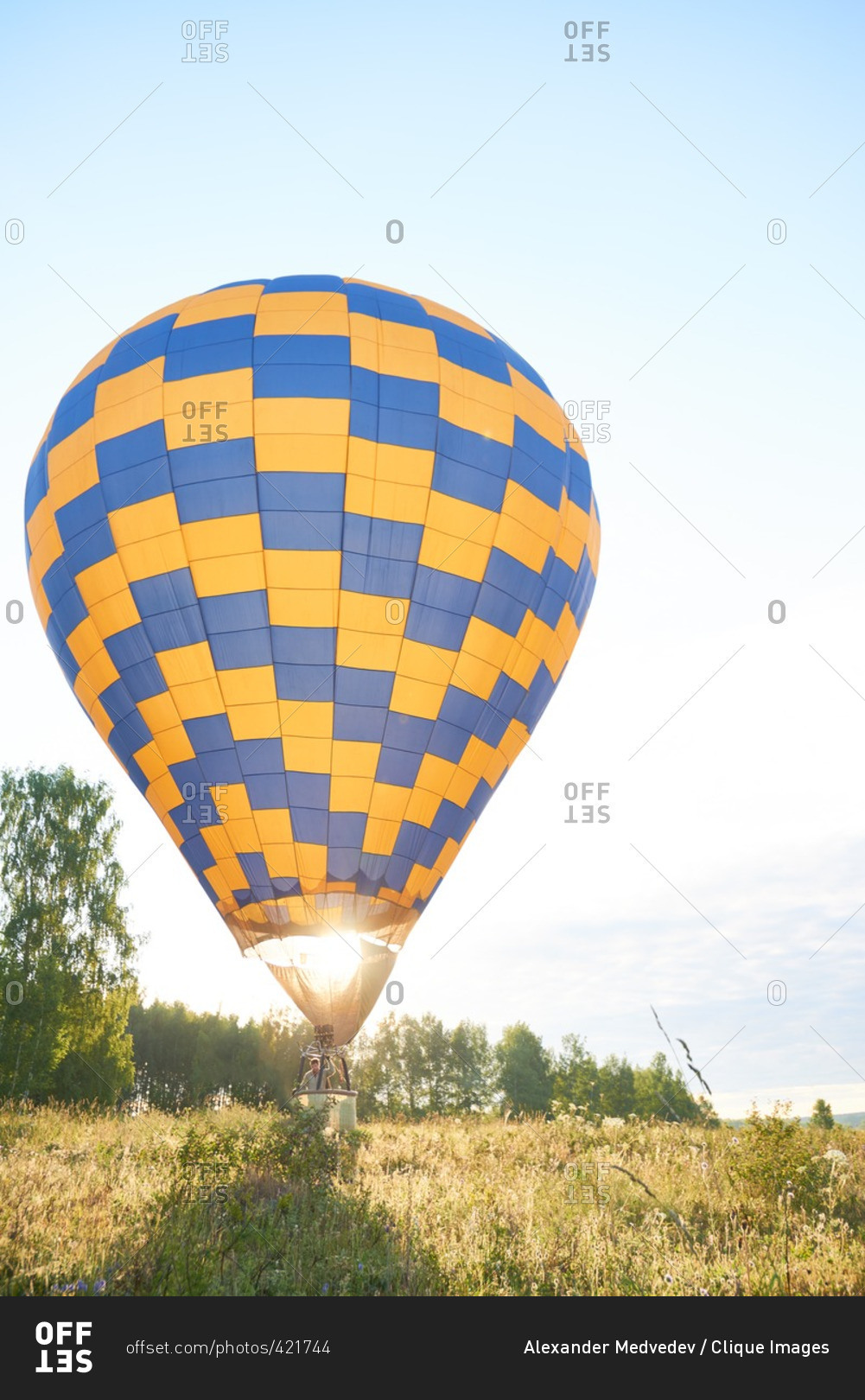 Man soaring in his hot air balloon amid the field
