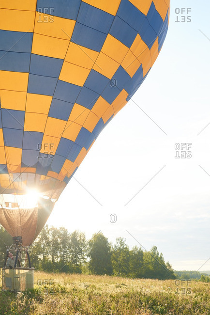 Man soaring in his hot air balloon amid the field