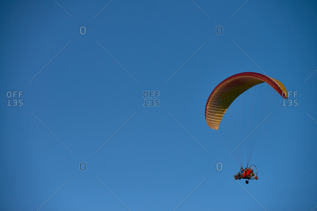 Two men driving powered paraglider