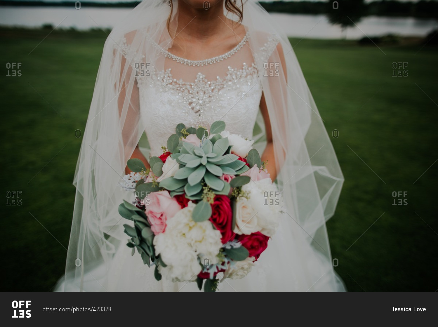 Mid-section of bride holding bouquet