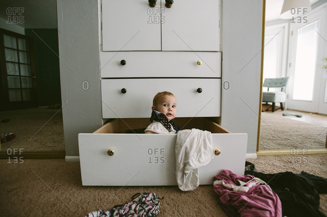 Baby playing in chest of drawers