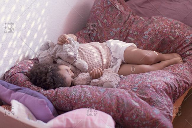 Little girl taking an afternoon nap with stuffed toy