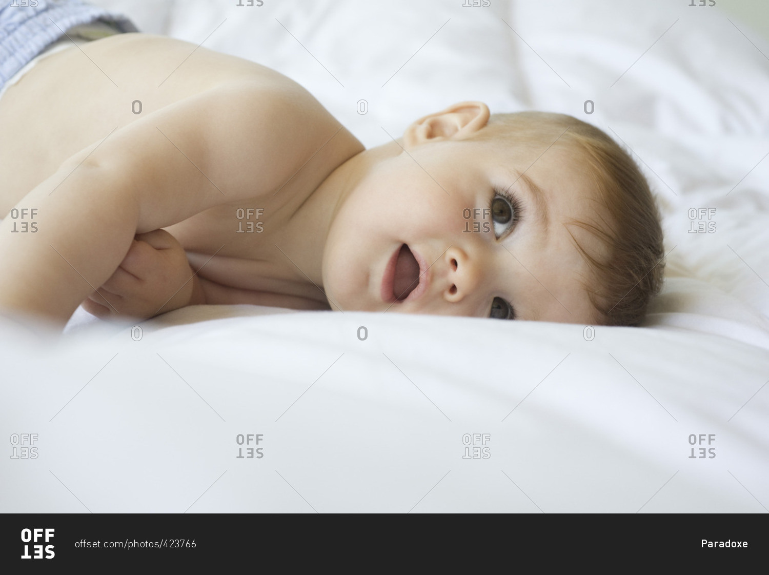Baby lying on blanket, looking up
