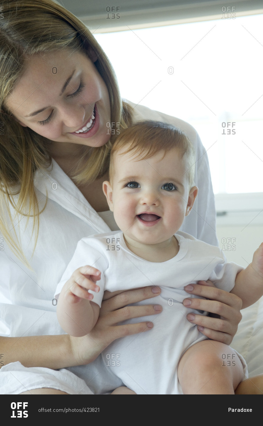 Mother holding happy baby on lap, portrait