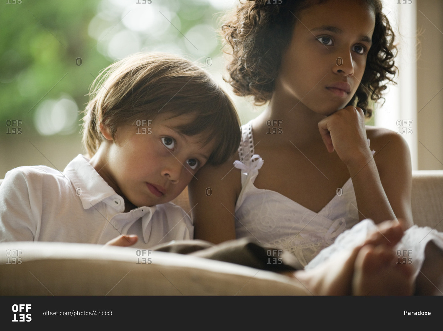 Children watching TV together, boy resting head on sister's shoulder