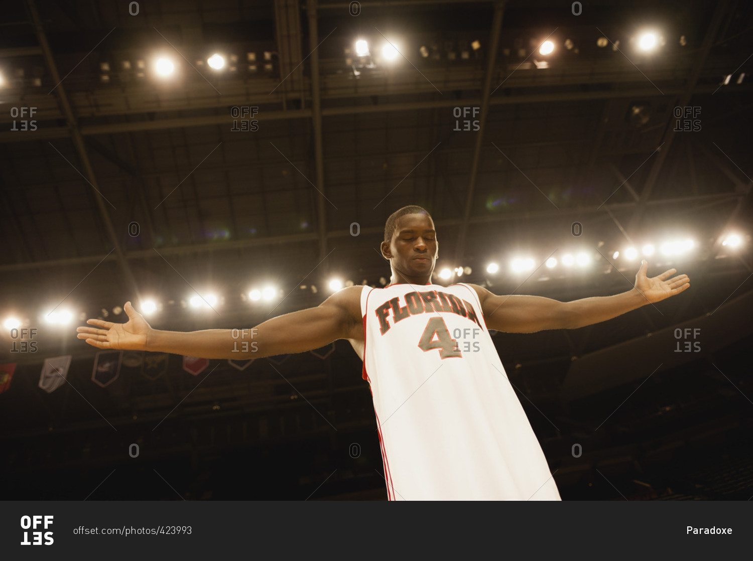 Basketball player standing with arms out, low angle view stock photo