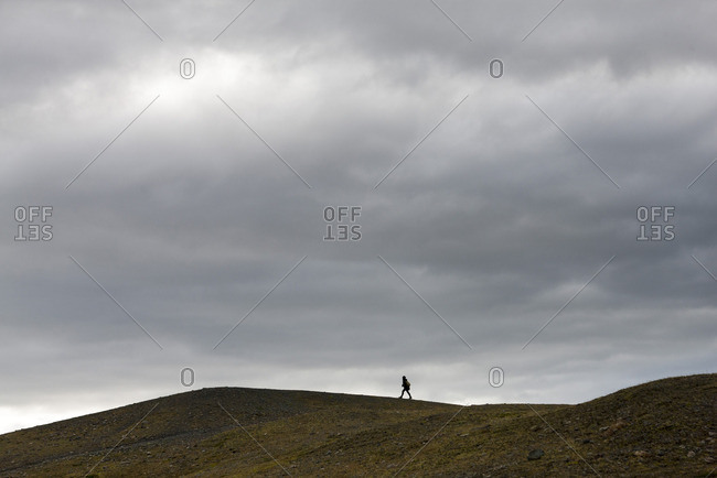 Iceland, person walking along barren hilltop
