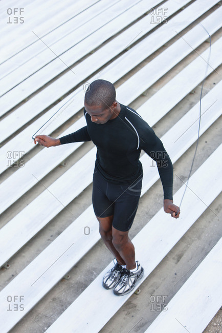 Man jumping rope on bleacher, high angle view