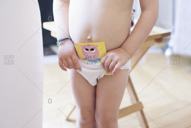 Little girl in her panties picking out what to wear stock photo - OFFSET