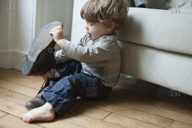 Toddler boy playing with parent's shoes