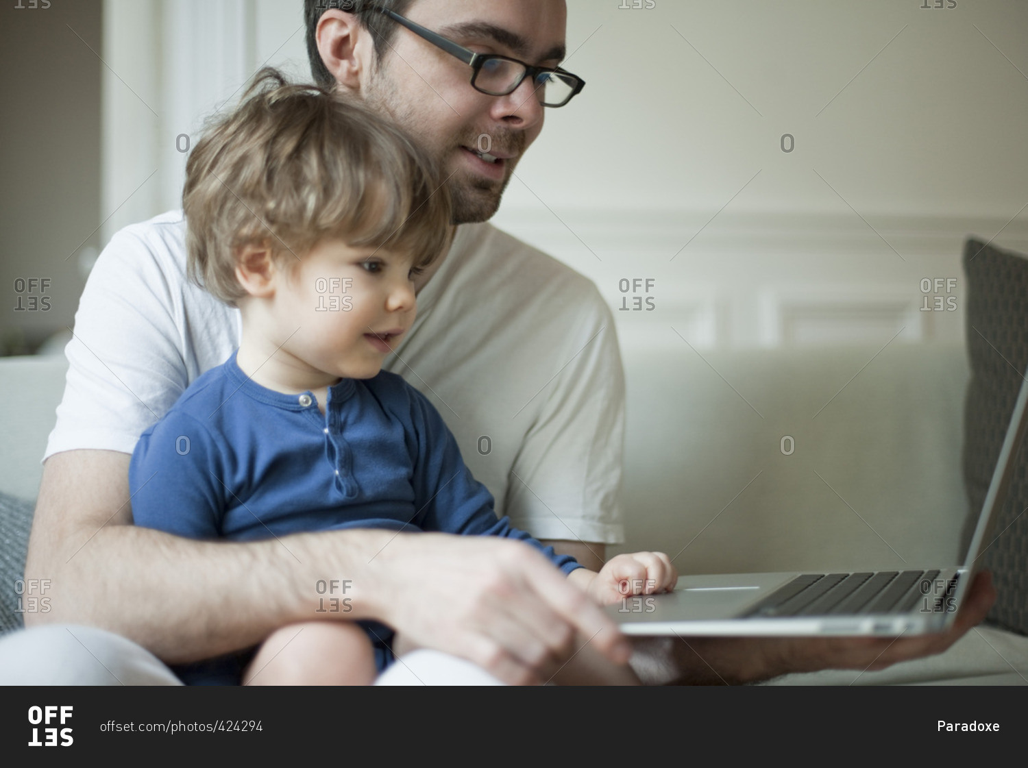Toddler boy using laptop computer with father