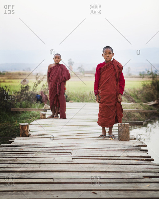 Asian boys in traditional robes walking on bridge
