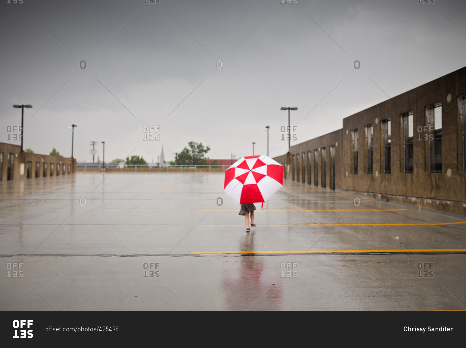 Little girl running in rain with umbrella
