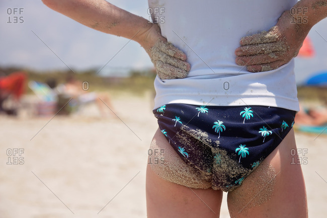 Little girl in underwear on rocky beach stock photo - OFFSET