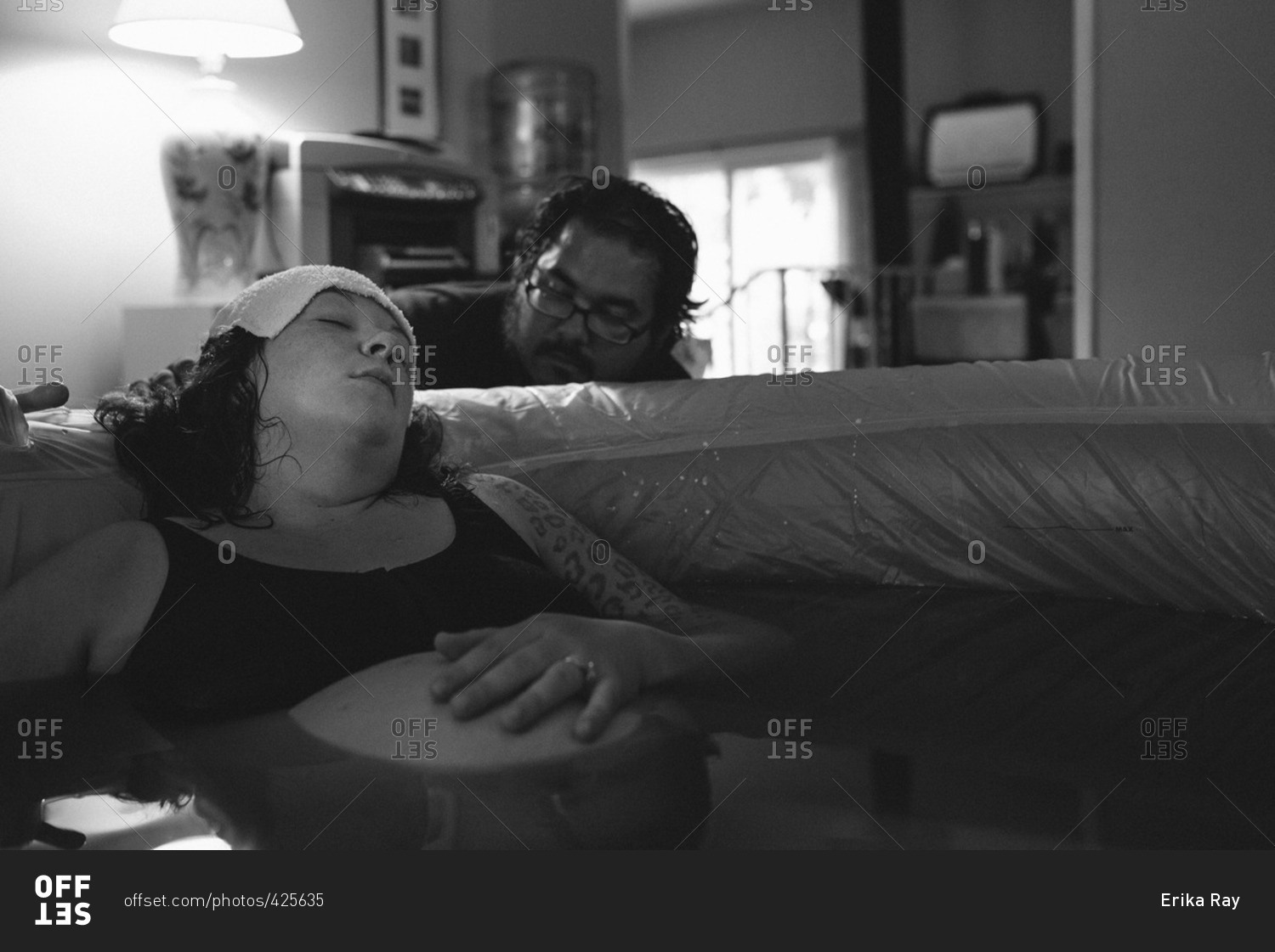 Woman being comforted by her husband during a home birth