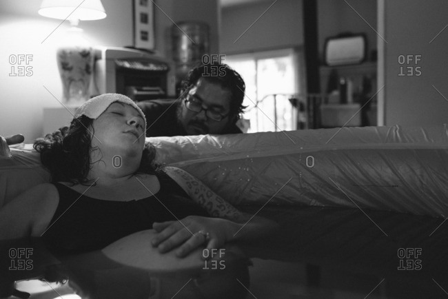 Woman being comforted by her husband during a home birth