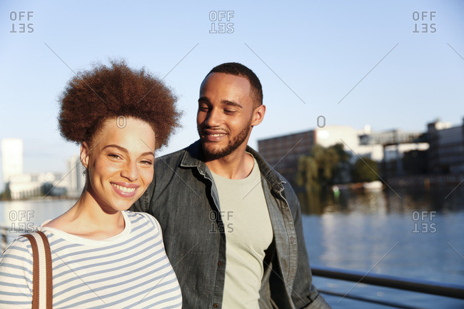 Happy young couple walking by river